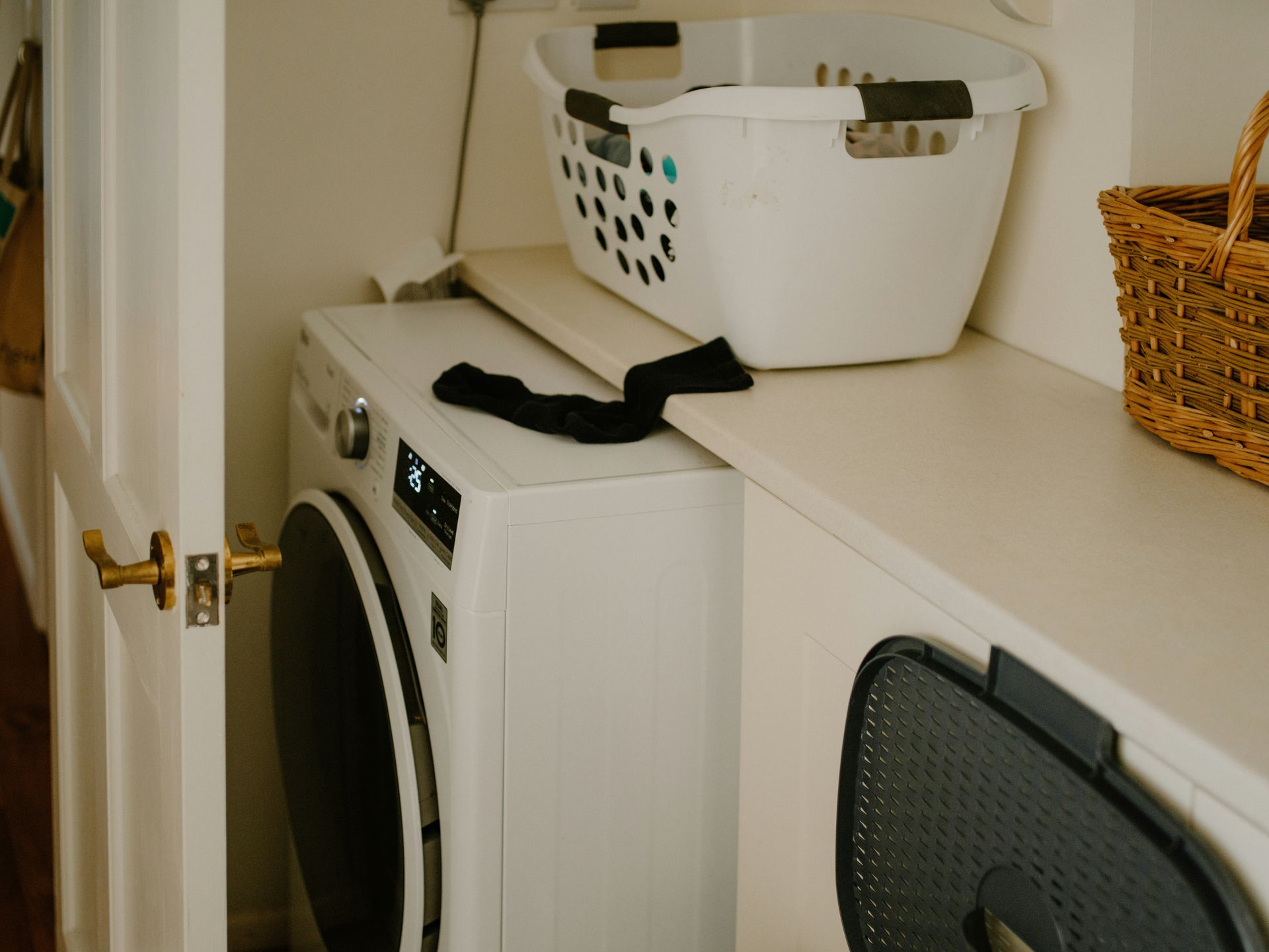 White washing machine with laundry basket and sock