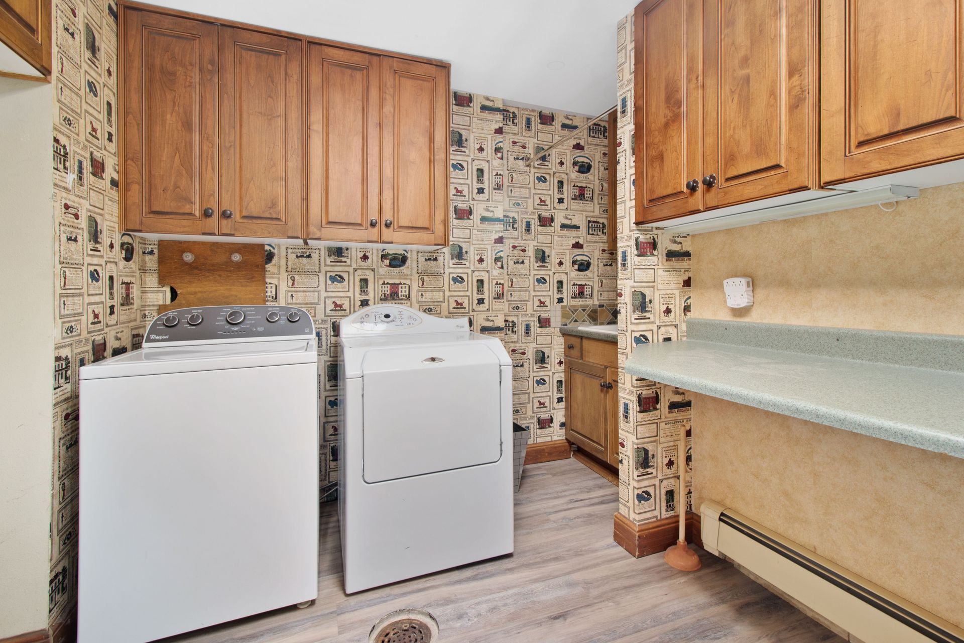Cozy laundry room with wooden cabinets, washer, and dryer setup.